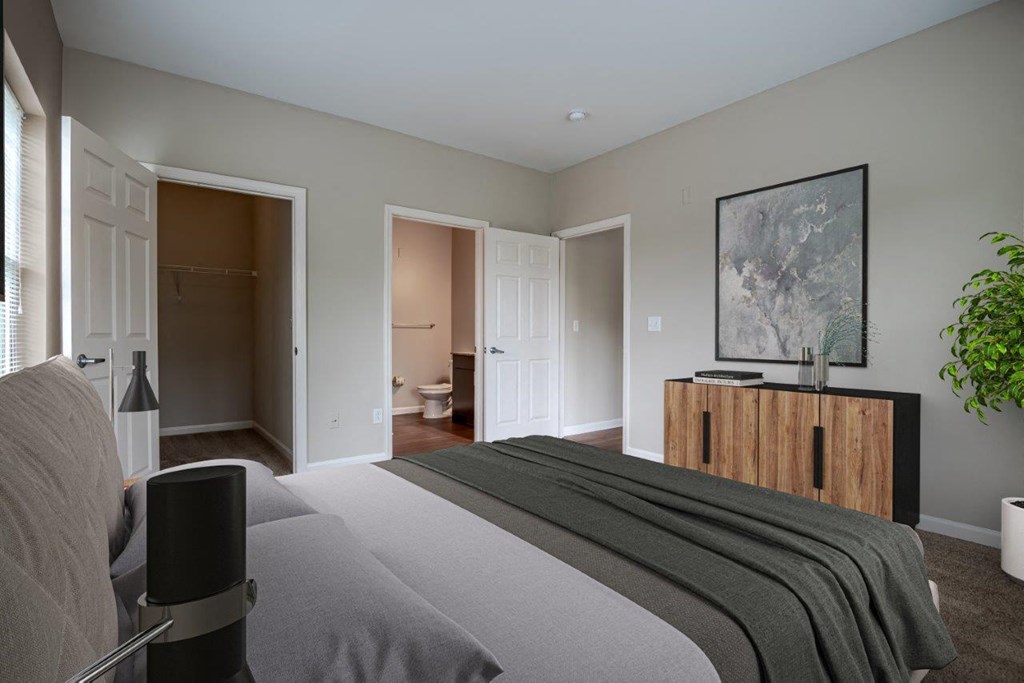 a bedroom with a bed and a dresser and a bathroom