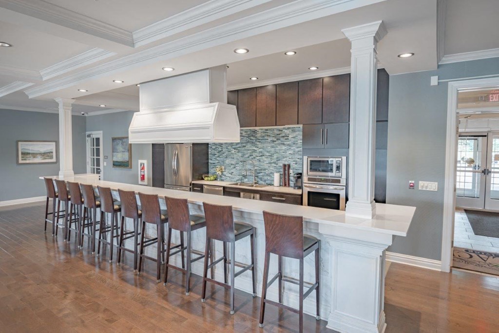 a large kitchen with a long bar and stools