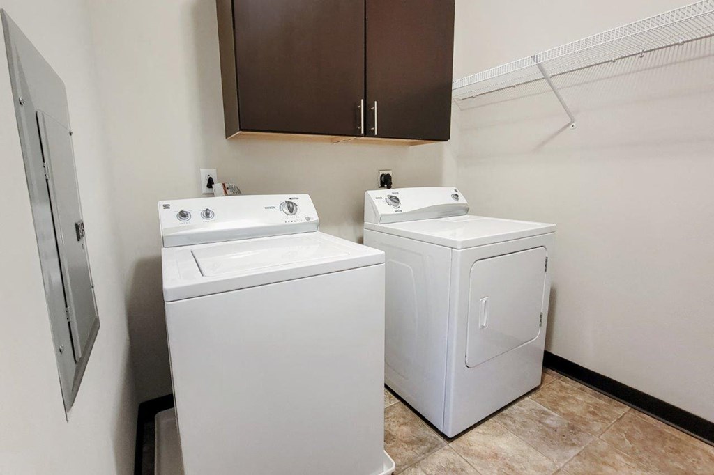 two washers and dryers in the laundry room of an apartment building