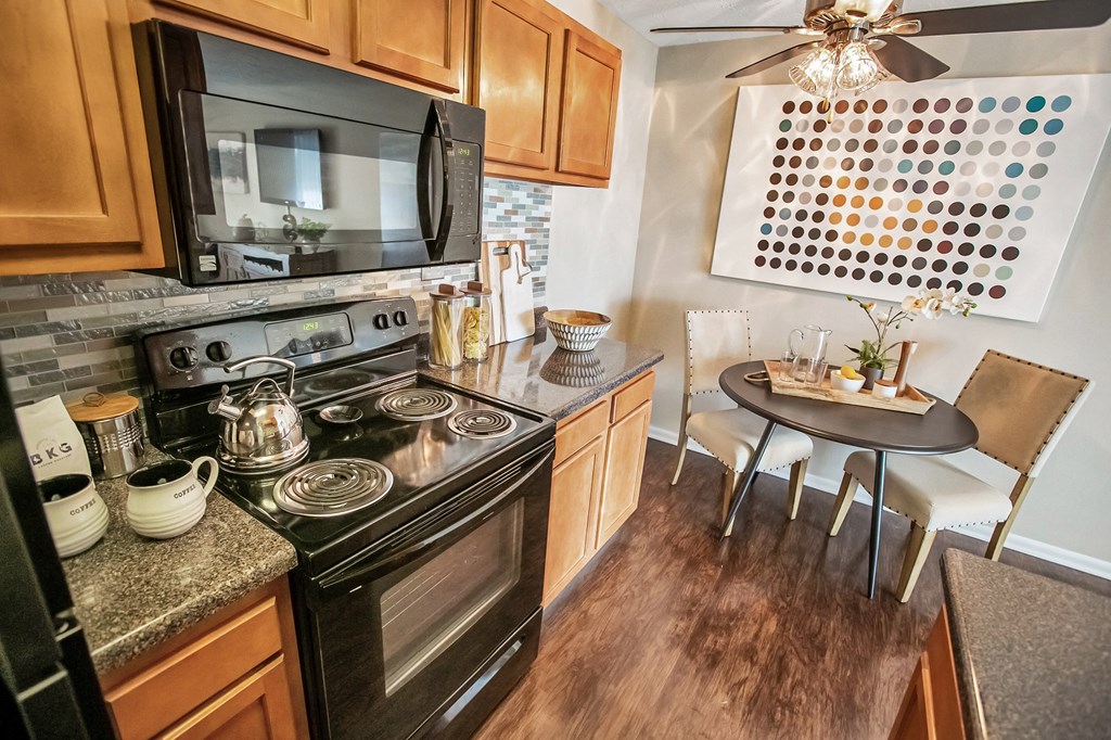 a kitchen with a stove and a microwave and a dining room table