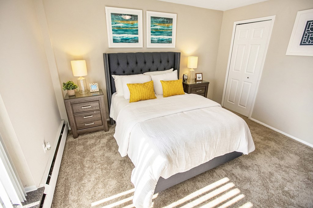 a bedroom with a white bed and two yellow pillows