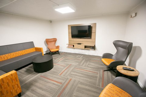 a living room with chairs and a television
