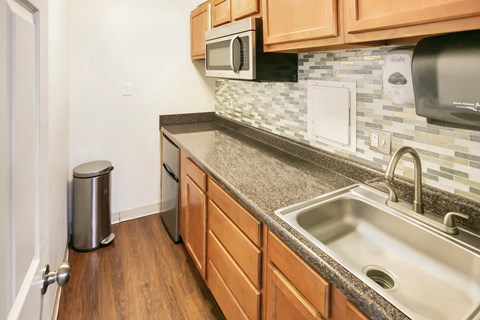 a kitchen with wood cabinets and granite counter tops and a sink