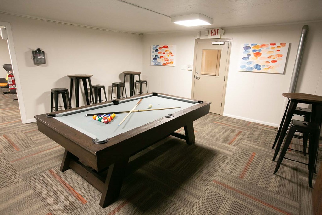 a games room with a pool table and bar
