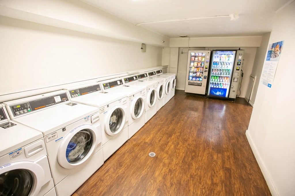 a washer and dryer room with a row of washing machines
