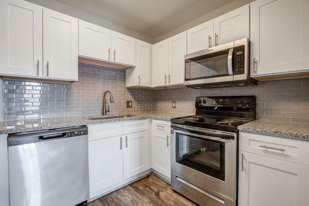 White Kitchen with Stainless-Steel Appliances and Granite Countertops