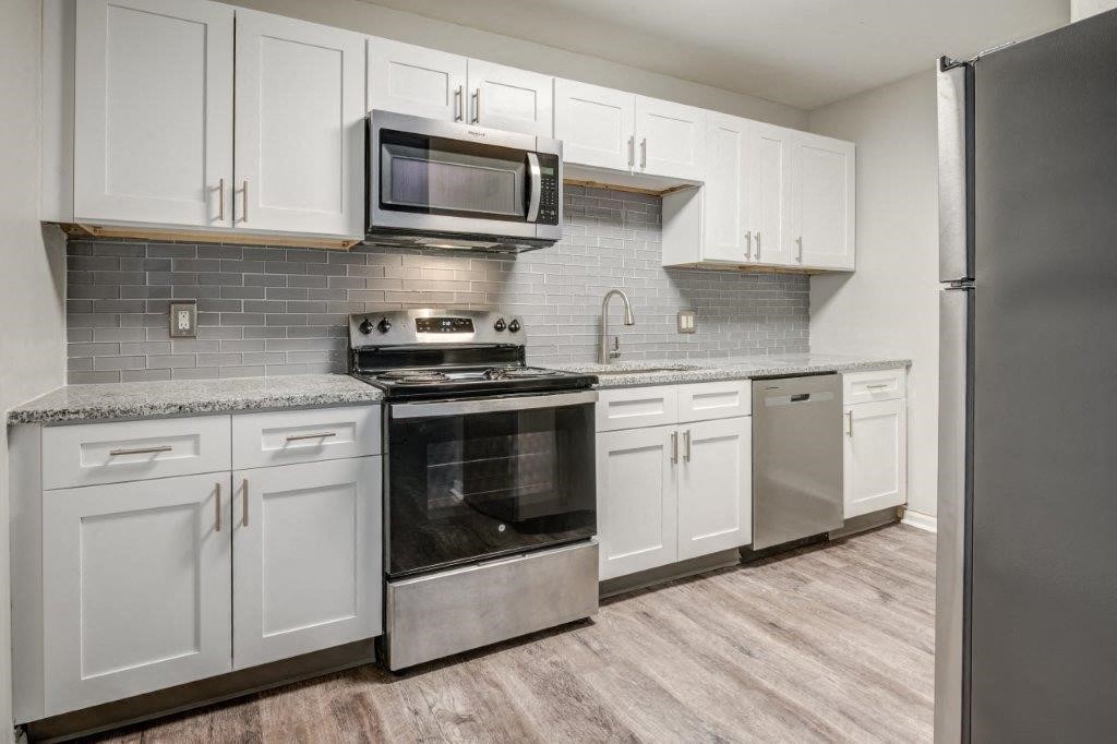 White Kitchen with Stainless-Steel Appliances and Granite Countertops