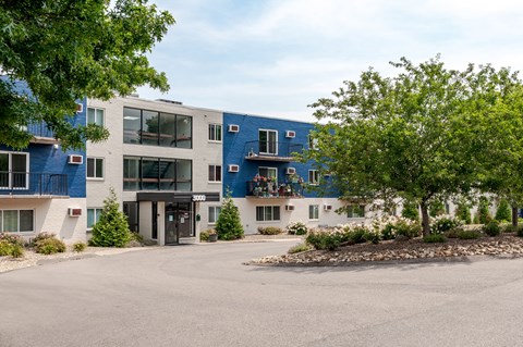 the exterior of a building with a parking lot and trees