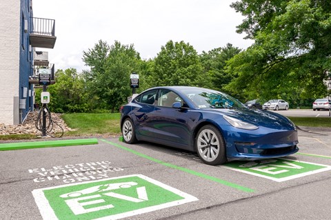 a electric car parked at a charging station in a parking lot