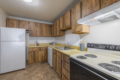 a kitchen with white appliances and wooden cabinets