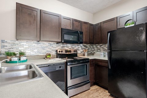 a kitchen with stainless steel appliances and a black refrigerator