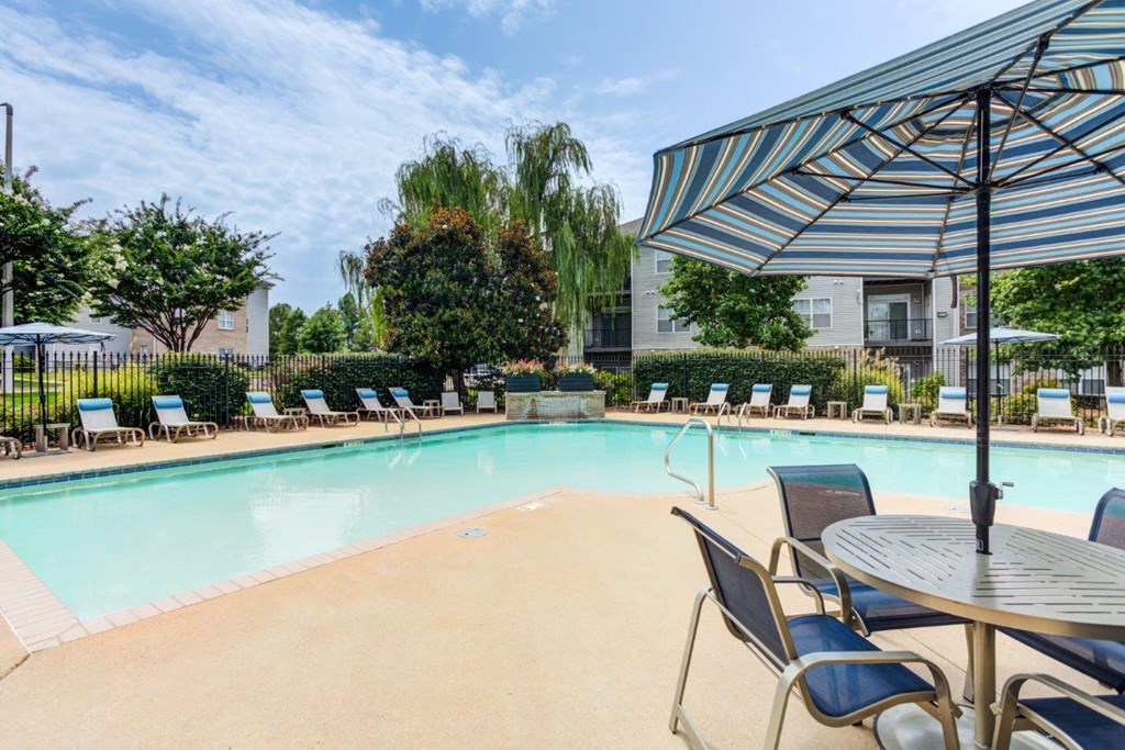 a swimming pool with tables and chairs and umbrellas