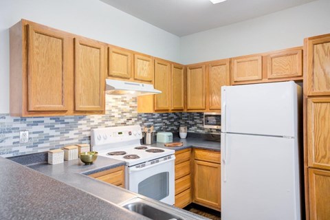 a kitchen with wooden cabinets and a white refrigerator