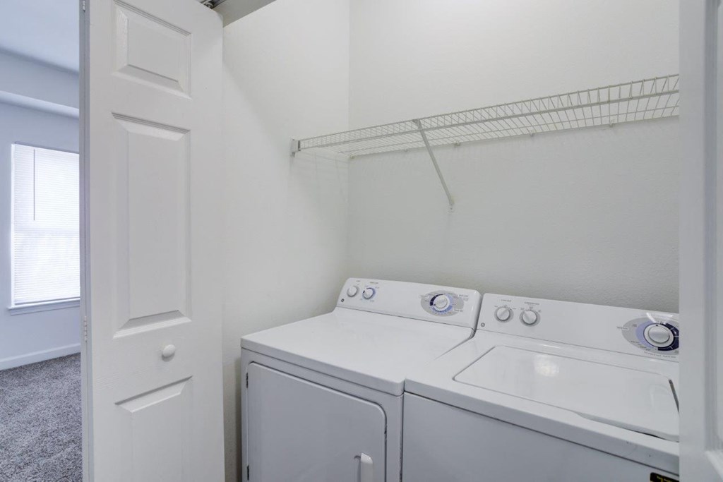a white washer and dryer in a white laundry room