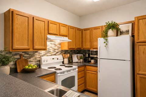 A kitchen with wooden cabinets and a white refrigerator.