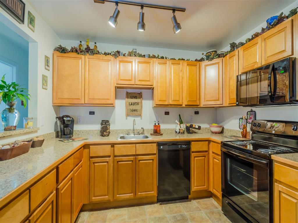 a kitchen with wooden cabinets and black appliances