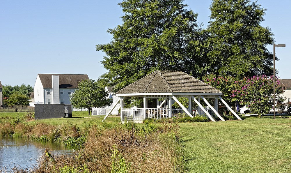 a gazebo in a park next to a river