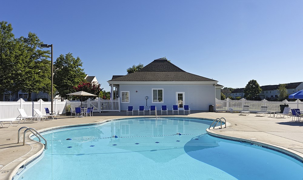 a swimming pool with a house in the background