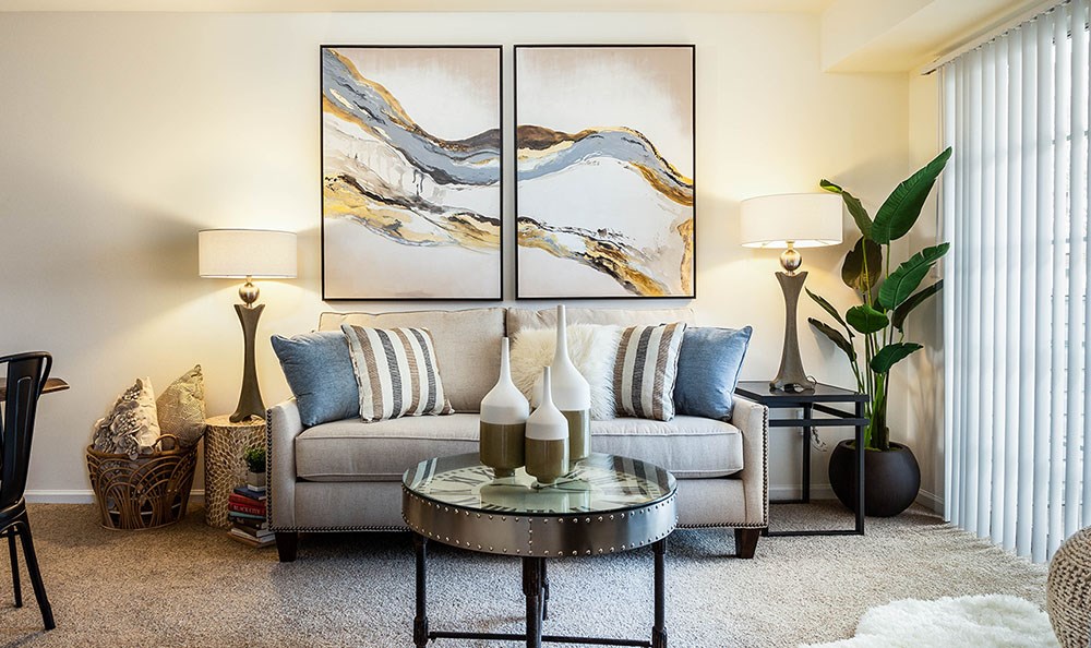 a living room with a couch and two paintings on the wall