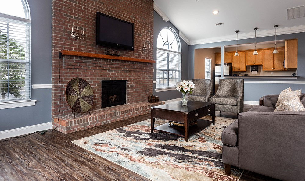 a living room with a brick fireplace and a tv