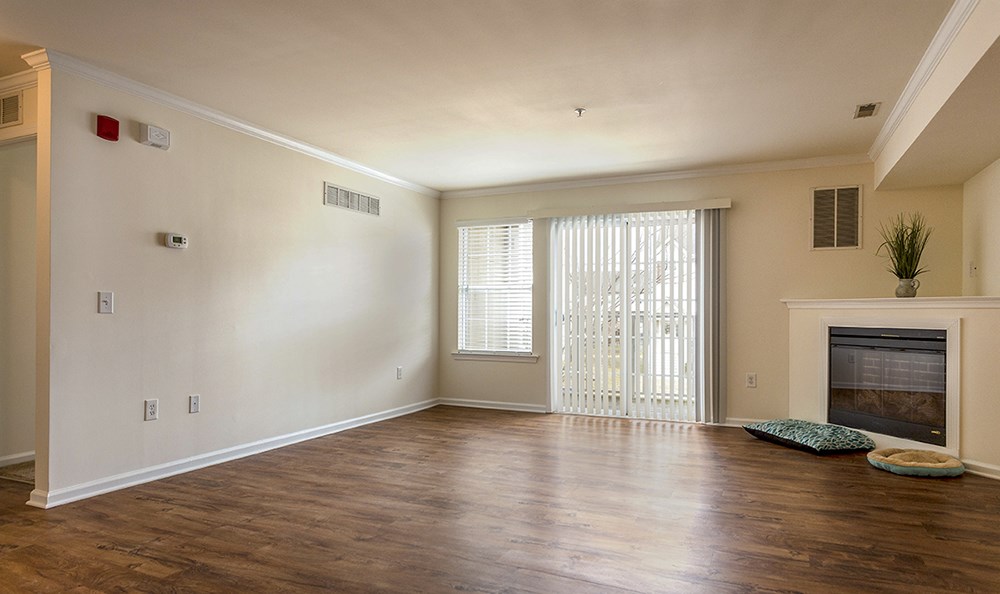 an empty living room with a fireplace and a window