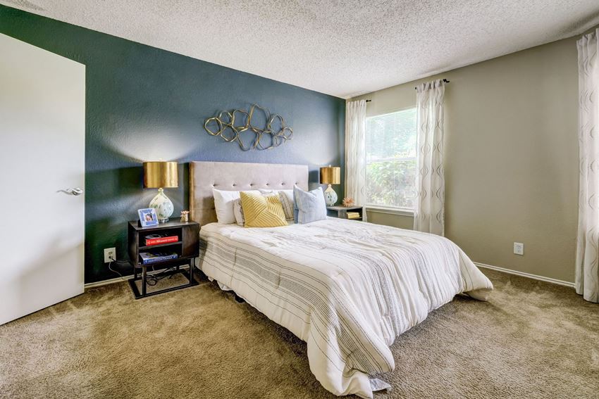 a bedroom with a bed and a green wall and a window