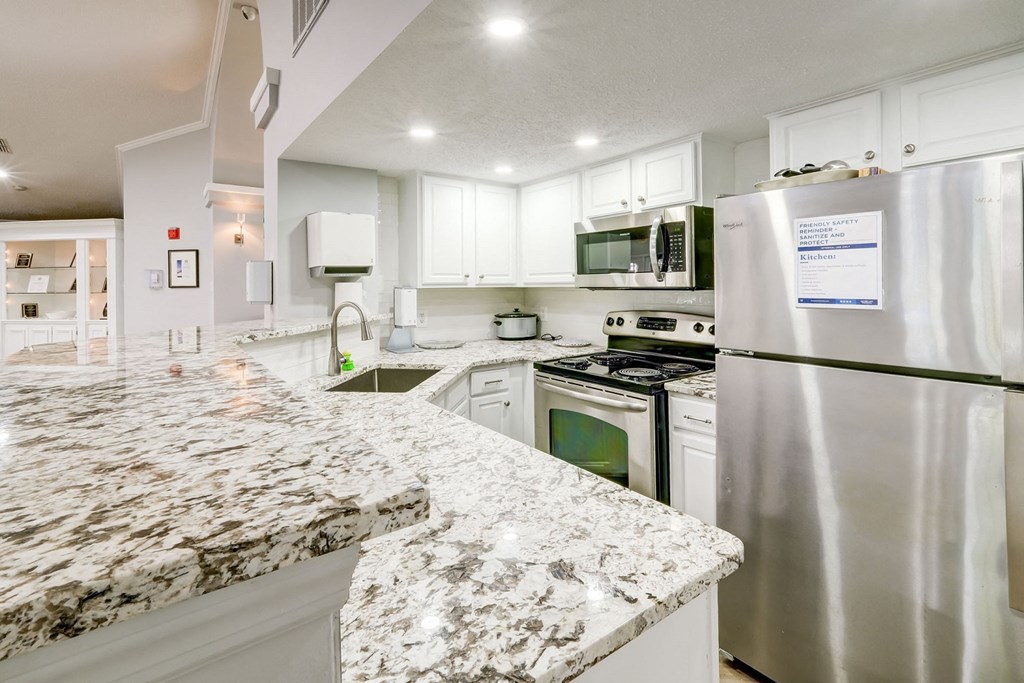 an updated kitchen with granite counter tops and stainless steel appliances