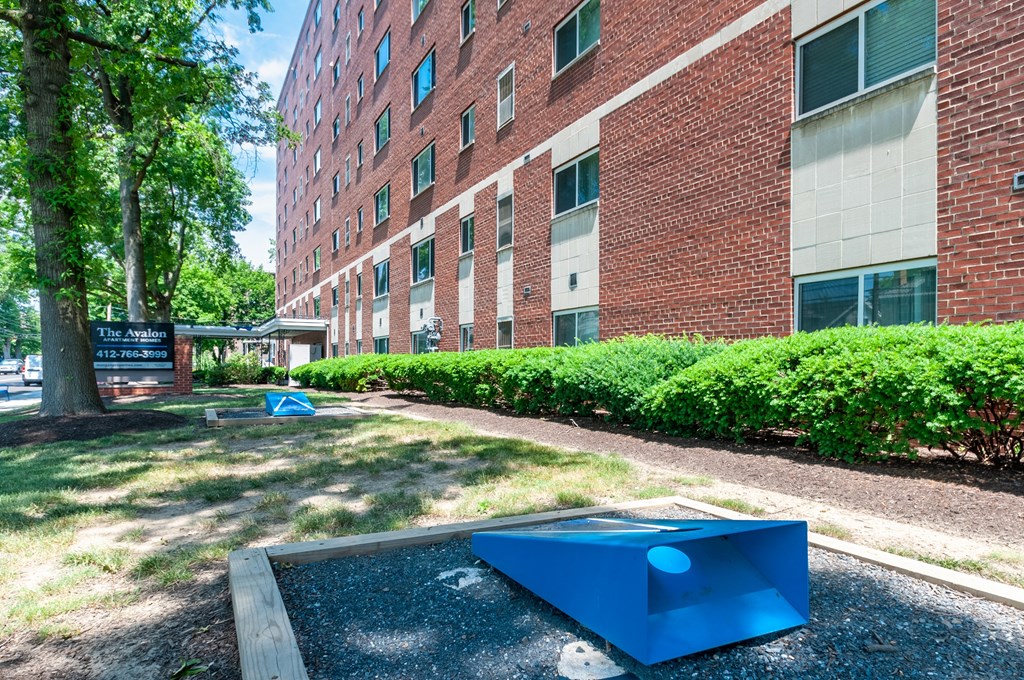 a blue ping pong table in front of a brick building