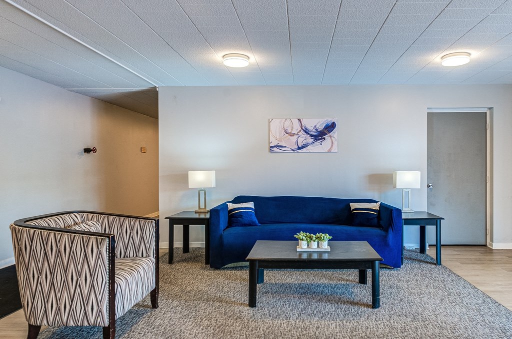 a living room with a blue couch and two chairs