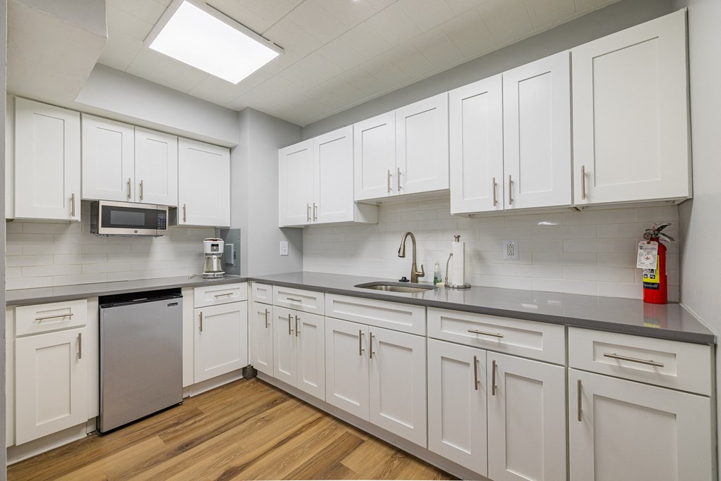 a large kitchen with white cabinets and stainless steel appliances