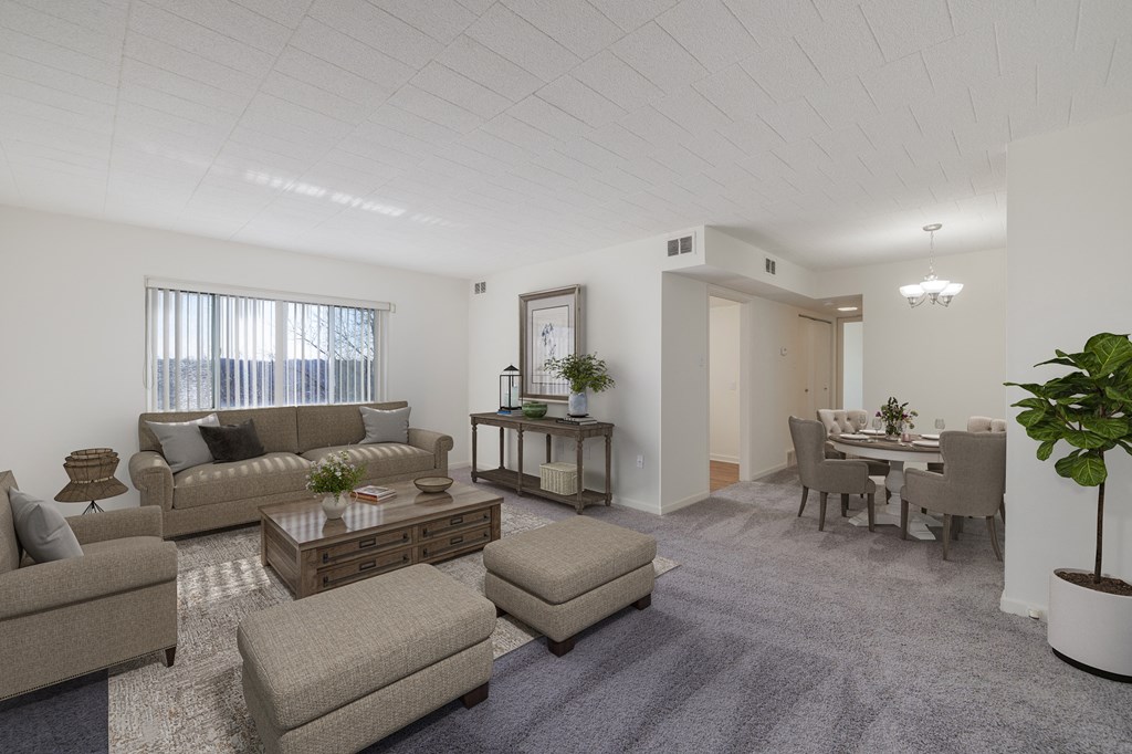 the living room and dining room of an apartment with couches and chairs
