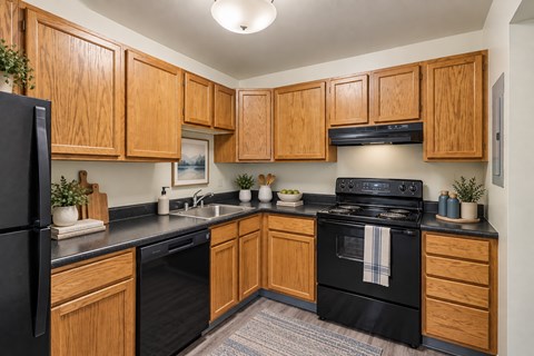 A kitchen with wooden cabinets and black appliances.