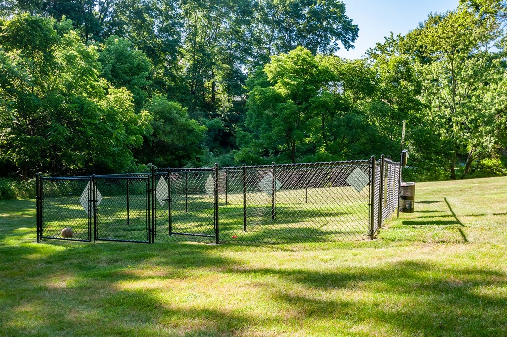 a chain link fence with a tennis court in a field