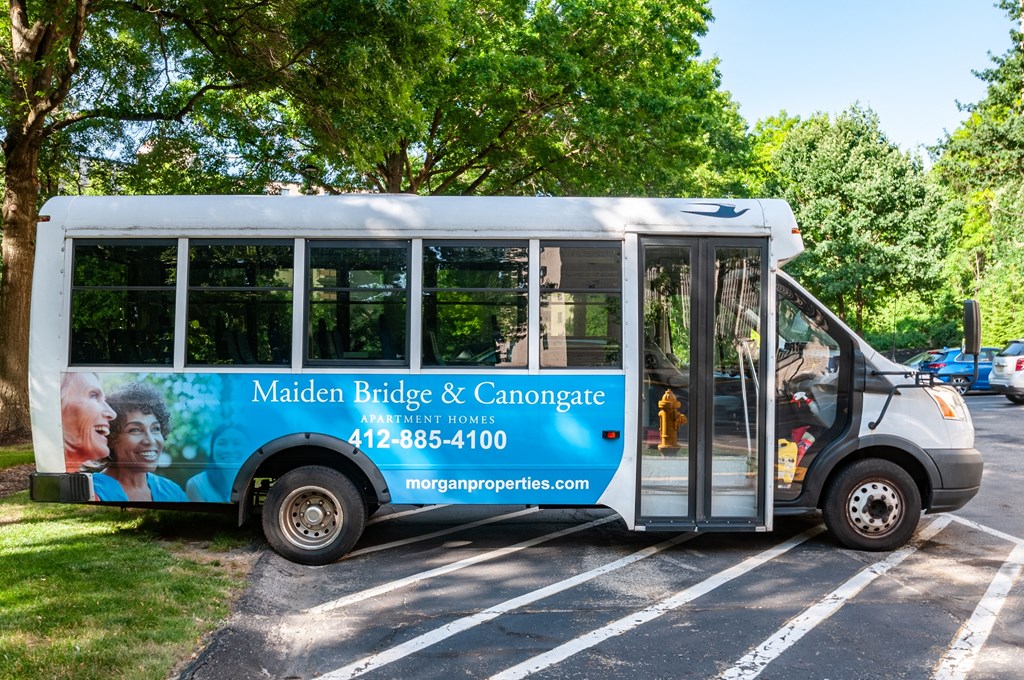 a bus parked in a parking lot with trees