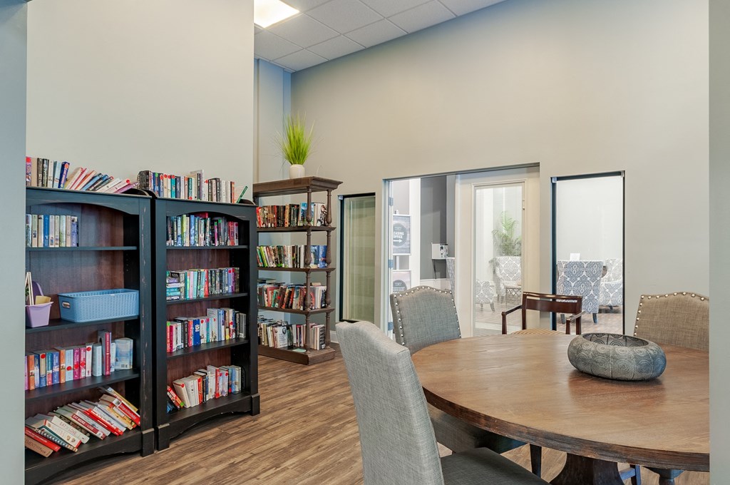 a library with a table and chairs and a bookshelf filled with books
