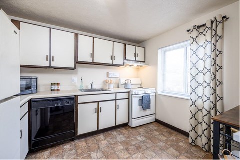 A kitchen with white cabinets and a black oven.