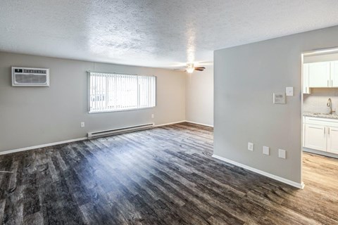 A room with a window and a wooden floor.