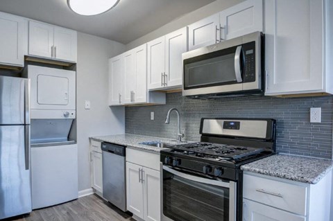 a kitchen with stainless steel appliances and white cabinets