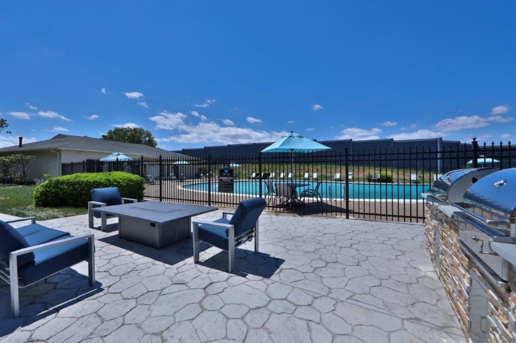 a patio with tables and chairs and a swimming pool