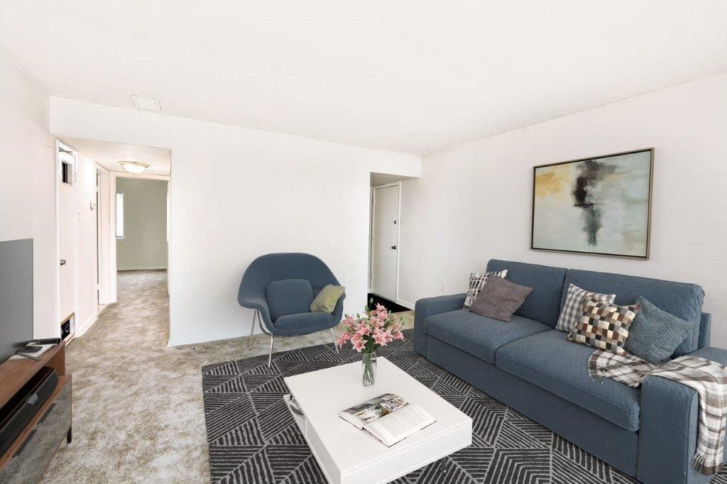 a living room with a blue couch and a white table