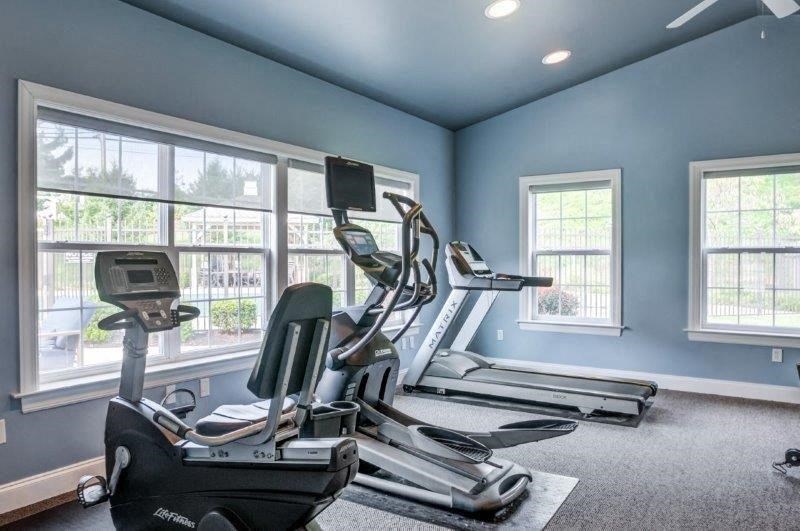 a gym with exercise equipment and large windows