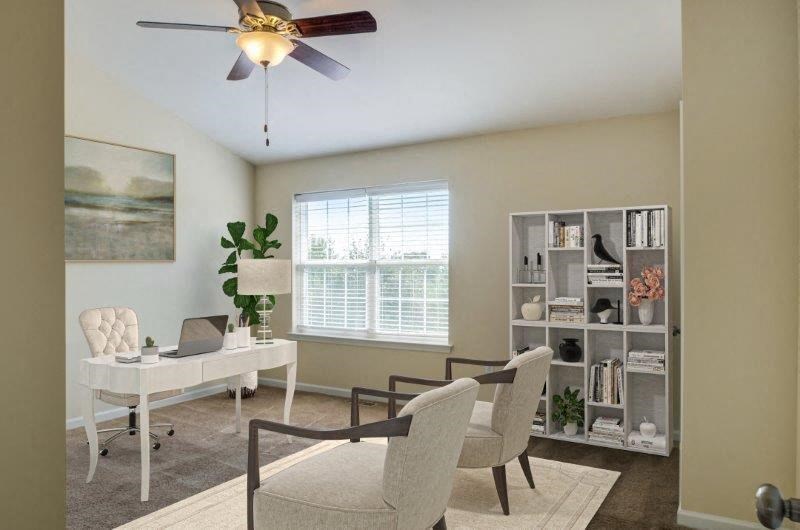an office with a desk and chairs and a ceiling fan