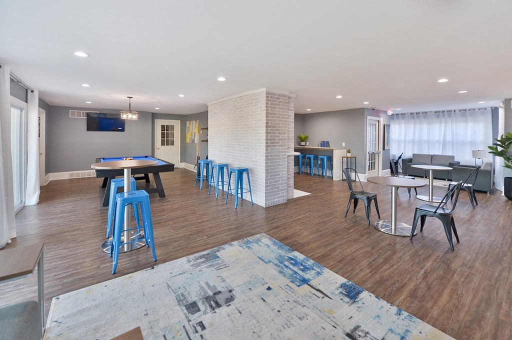 an empty clubhouse with tables and chairs and a pool table