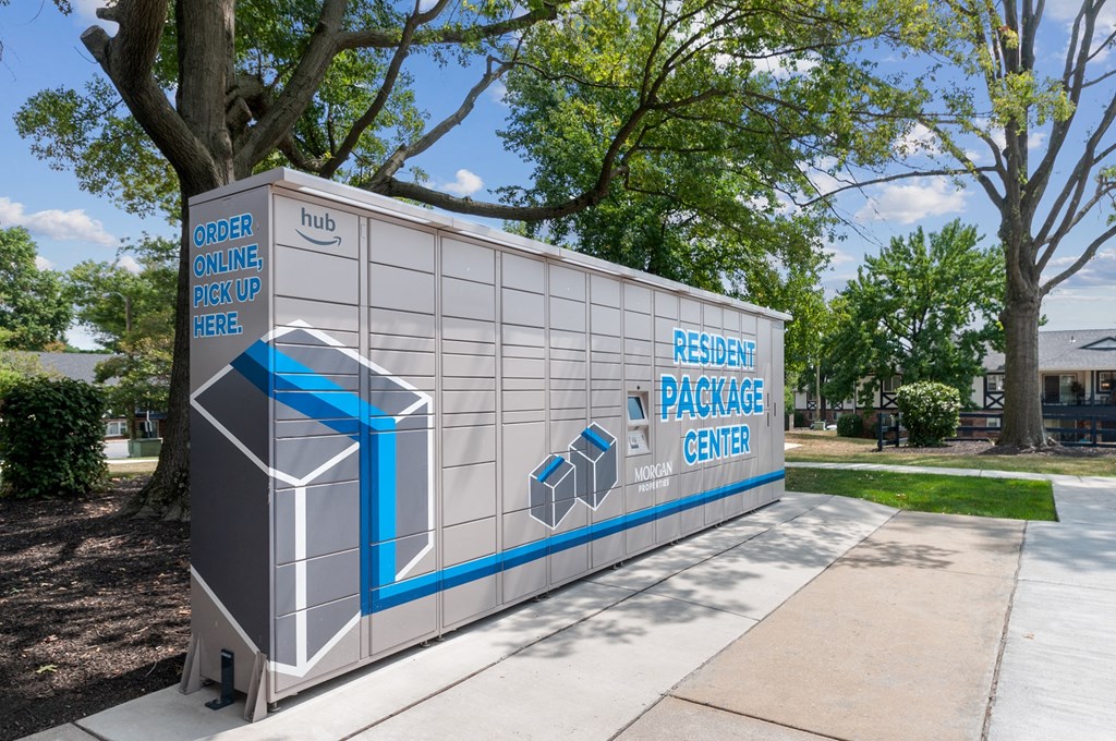 a gray and blue building with a sidewalk and trees