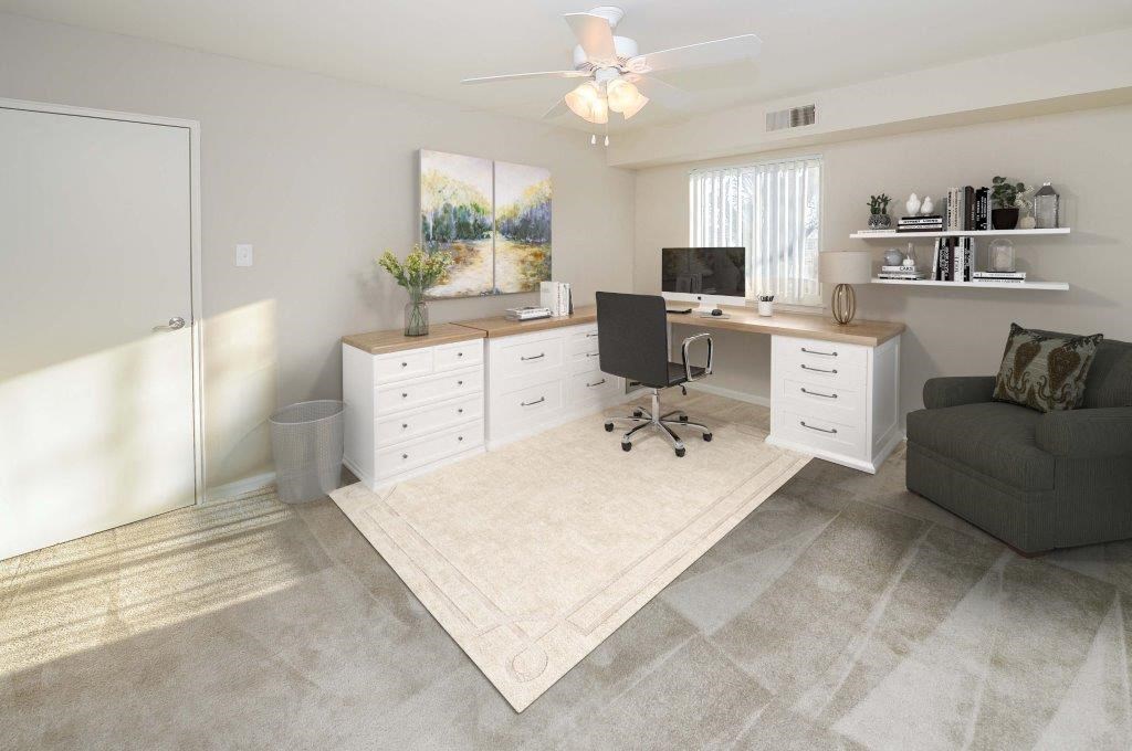 a living room with a desk and a couch