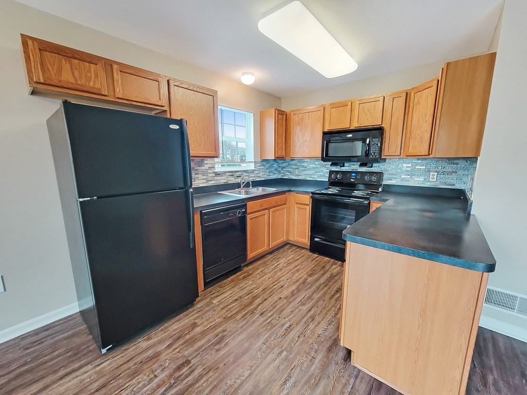 a kitchen with black appliances and wooden cabinets