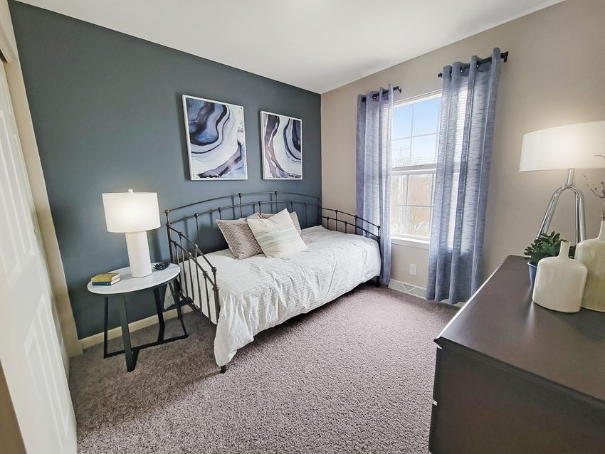an empty bedroom with a bed and a window