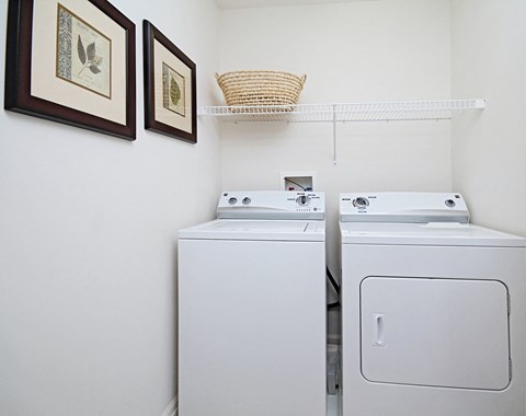 a white washer and dryer in a white laundry room with two white machines