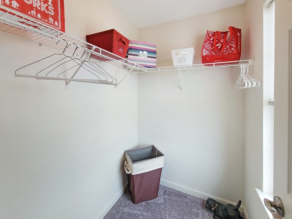 a small closet with a shelf and a trash can in it