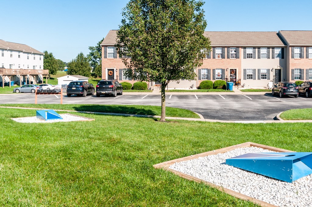 a parking lot with cars parked in front of an apartment building